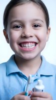Happy young girl with toothbrush and toothpaste showing healthy smile after dental care routine. Child demonstrating proper oral hygiene habits and dental health.