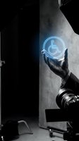 Hand holding glowing wheelchair accessibility icon in dark industrial setting, symbolizing inclusive digital technology and disability support services for web and app development.