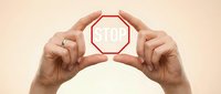Hands holding red stop sign symbol for safety warning and traffic control concepts on neutral background.