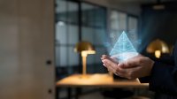 Businessman holding holographic pyramid with data visualization in modern office environment for technology and innovation concepts.