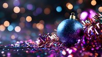 Glittery blue Christmas ball ornament with pink tinsel garland against blurred bokeh lights background creating magical holiday atmosphere.
