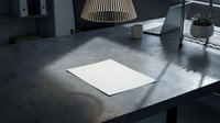 Modern minimalist workspace with blank white paper on concrete desk under pendant lamp creating dramatic shadows for creative projects and presentations.