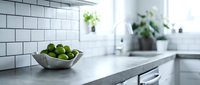 Fresh green limes in a modern kitchen with white subway tile backsplash and marble countertop, suitable for food and lifestyle design projects.