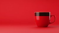 Red ceramic coffee cup with black stripe on vibrant red background, minimalist composition with copy space for text or product placement.
