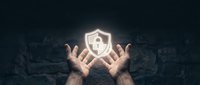Two hands with palms up holding a glowing shield with padlock symbol against dark textured background, representing data protection, cybersecurity, and digital safety for business applications.