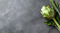 Fresh green artichoke with leaves on dark stone background with copy space. Minimalist food photography for restaurant menu and healthy eating concept.