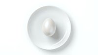 White chicken egg in ceramic bowl on white background isolated for cooking and food design projects.
