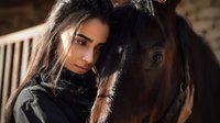 Young woman with long dark hair embracing brown horse in stable, creating intimate bond between human and animal in warm natural lighting.