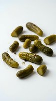 Assorted pickled gherkins and cornichons isolated on white background, ready for food packaging, recipe blogs, culinary websites, and restaurant menus.