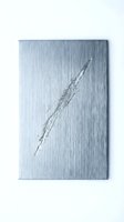 Brushed metal surface with diagonal scratch mark showing wear and industrial texture for manufacturing and construction projects.
