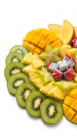 Fresh tropical fruit platter with sliced mango, kiwi, pineapple and dragon fruit arranged on white background for healthy eating and summer recipes.