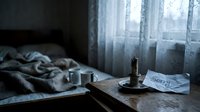 Dark moody bedroom with a burned-out candle, a sorry note, and a cup on a wooden table, evoking loneliness, regret, and emotional pain.