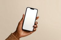 African American woman hand holding modern smartphone with blank white screen mockup against neutral beige background for app presentation.