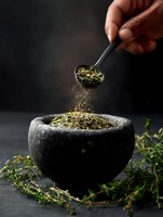 Dried herbs falling from spoon into stone mortar on dark background with fresh thyme sprigs, dramatic lighting creates moody culinary atmosphere.