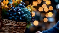 Fresh produce basket with dark blue grapes and broccoli against blurred warm bokeh lights creating cozy autumn atmosphere for seasonal food photography.