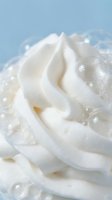 Creamy white frosting swirl with sparkling sugar crystals on soft blue background for bakery and dessert designs.