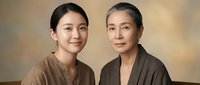 Two Asian women of different generations smiling warmly, representing family bonds, mother daughter relationship, and intergenerational connection in portrait.