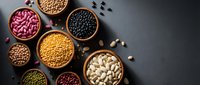 Assorted legumes and beans in wooden bowls on dark background. Healthy protein sources including lentils, chickpeas, kidney beans for cooking and nutrition.