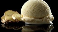 Creamy vanilla ice cream scoop with chocolate brownie and caramelized pineapple slices on reflective black surface, dramatic lighting creates appetizing dessert composition.