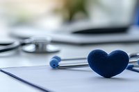 Blue heart-shaped object on stethoscope in medical office setting, symbolizing healthcare, cardiology, and compassionate patient care.