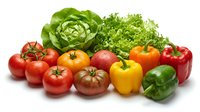 Fresh organic vegetables including tomatoes, bell peppers, lettuce and herbs isolated on white background for healthy cooking and nutrition concepts.