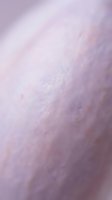 Soft lavender powder texture with fine granules creating a smooth, blurred surface in shades of purple and pink. Suitable for cosmetics, beauty products, skincare backgrounds.