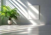 Minimalist interior with white blank frame on gray wall, palm plant in ceramic pot, and dramatic window light casting geometric shadows.