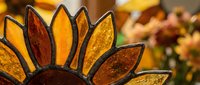 Stained glass sunflower with amber and golden petals creating warm decorative art piece for home decor and craft projects.