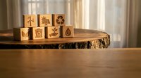 Wooden blocks with environmental and sustainability icons arranged on natural tree slice surface, representing eco-friendly concepts and green living practices.