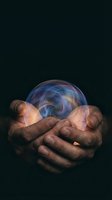 Hands of male person with dark skin tone holding glowing orb with swirling blue and golden energy against black background, representing future vision, spirituality, and mystical power for concepts.