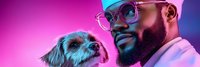 African American male veterinarian with beard and glasses examining small terrier dog in modern clinic with vibrant purple and blue neon lighting atmosphere.
