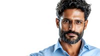 Middle-aged South Asian man with salt and pepper beard wearing light blue business shirt and glasses, looking confidently at camera against white background, professional headshot style.