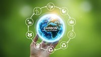 Carbon neutral concept with hand holding glowing Earth surrounded by environmental sustainability icons on green background for eco-friendly business.