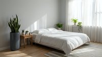 Modern minimalist bedroom interior with white bedding, wooden furniture, snake plant in gray planter, natural light through sheer curtains on hardwood floors.