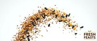 Mixed seeds and grains scattered in dynamic arc motion on white background. Healthy organic ingredients for cooking and nutrition concepts.