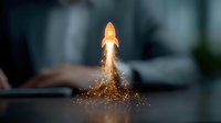 Orange rocket launching with glowing particles and smoke trail against blurred office background, symbolizing business startup and innovation success.