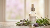Lavender essential oil dropper bottle with fresh purple lavender flowers and green herbs on wooden surface near bright window for aromatherapy and wellness.