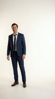 Confident young Caucasian businessman in navy blue suit and tie standing with hands in pockets on white background for corporate presentations.