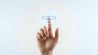 Hand pressing glowing activate button on futuristic digital interface for business technology and user interaction concepts.