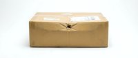 Damaged brown cardboard shipping box with torn packaging tape on white background isolated for delivery and logistics concepts.