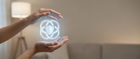 Hands protecting glowing atomic symbol representing nuclear energy safety and environmental protection in modern home interior.