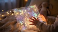 Young woman reading magical glowing book with fantasy illustrations in cozy bedroom setting with warm bokeh lights creating enchanting storytelling atmosphere.