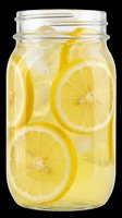 Glass jar filled with fresh lemon slices and clear liquid with ice cubes, isolated on transparent background. Ready for beverage, recipe, wellness, and kitchen design projects including t-shirts, clipart, and print-on-demand products.