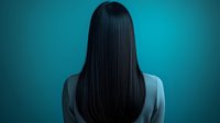 Young Asian woman with long straight black hair shown from behind against turquoise background, wearing grey blazer, mysterious atmospheric portrait.