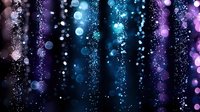 Magical glowing sparkles and bokeh lights cascading down on dark background in blue and purple colors create dreamy atmospheric effect for festive designs.