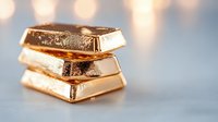 Stacked gold bars with reflective surface on blurred background. Luxury investment and banking concept showing wealth, prosperity and financial success.