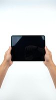 Male hands holding tablet with blank black screen isolated on white background, suitable for app mockups and digital device presentations.