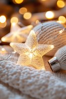 Glowing star-shaped light decoration on white knitted fabric with warm bokeh background creates cozy holiday atmosphere for seasonal greetings and winter celebrations.