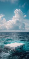 Minimalist concrete platform floating on turquoise ocean waters under dramatic cumulus clouds and bright blue sky, creating surreal seascape atmosphere.