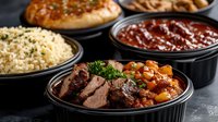 Hearty beef stew with tender chunks, carrots and herbs served in bowl alongside rice, bread and sauce for complete comfort meal.